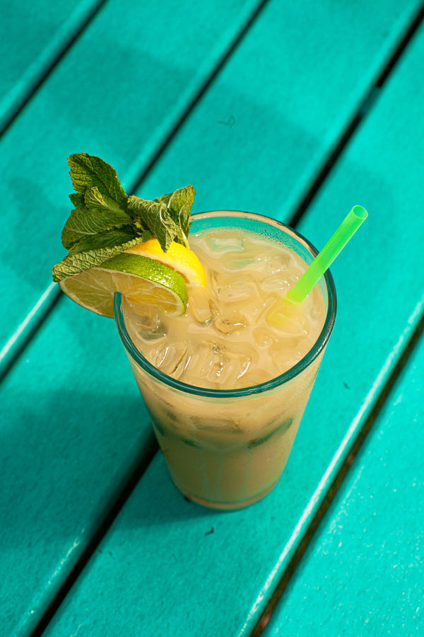 Mojito-style botanical drink on the teal deck